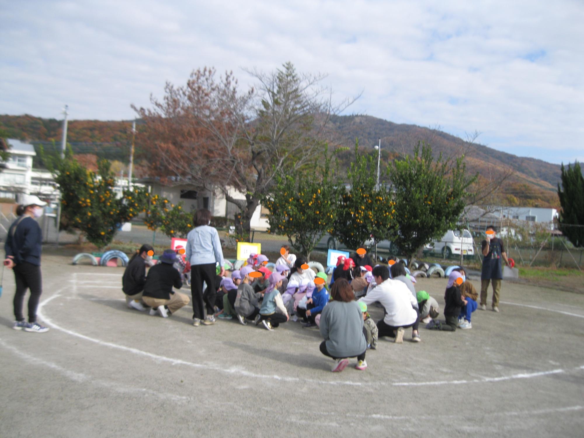 みかんの木の前で子どもたちが話をきいています。