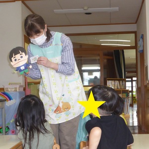 富田先生がまあくん人形を使って野菜のお話をしている写真