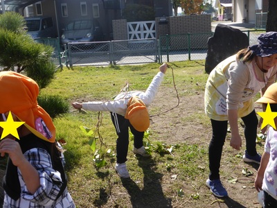 おいものつるで、縄跳びをする子どもの写真