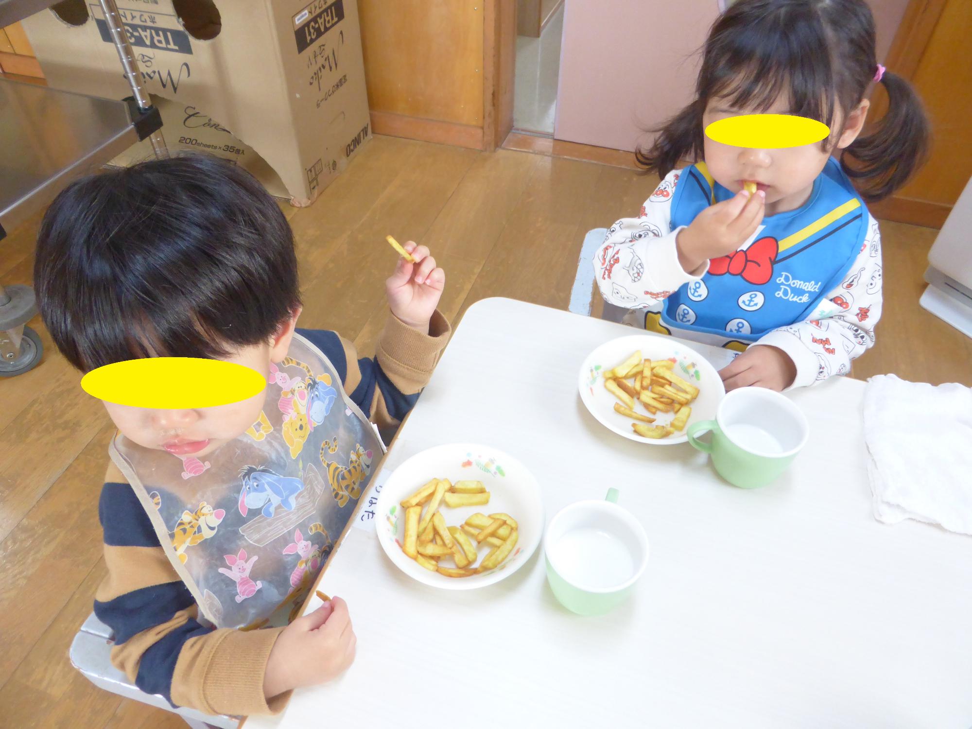 1歳児がおいしそうにいもけんぴを食べています。