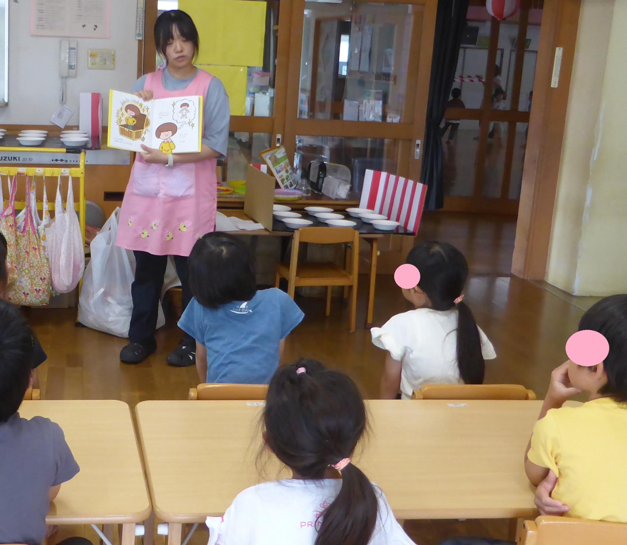 看護士が、年長の子どもたちに、絵本を使って自分の体の大切な場所の話をしています。