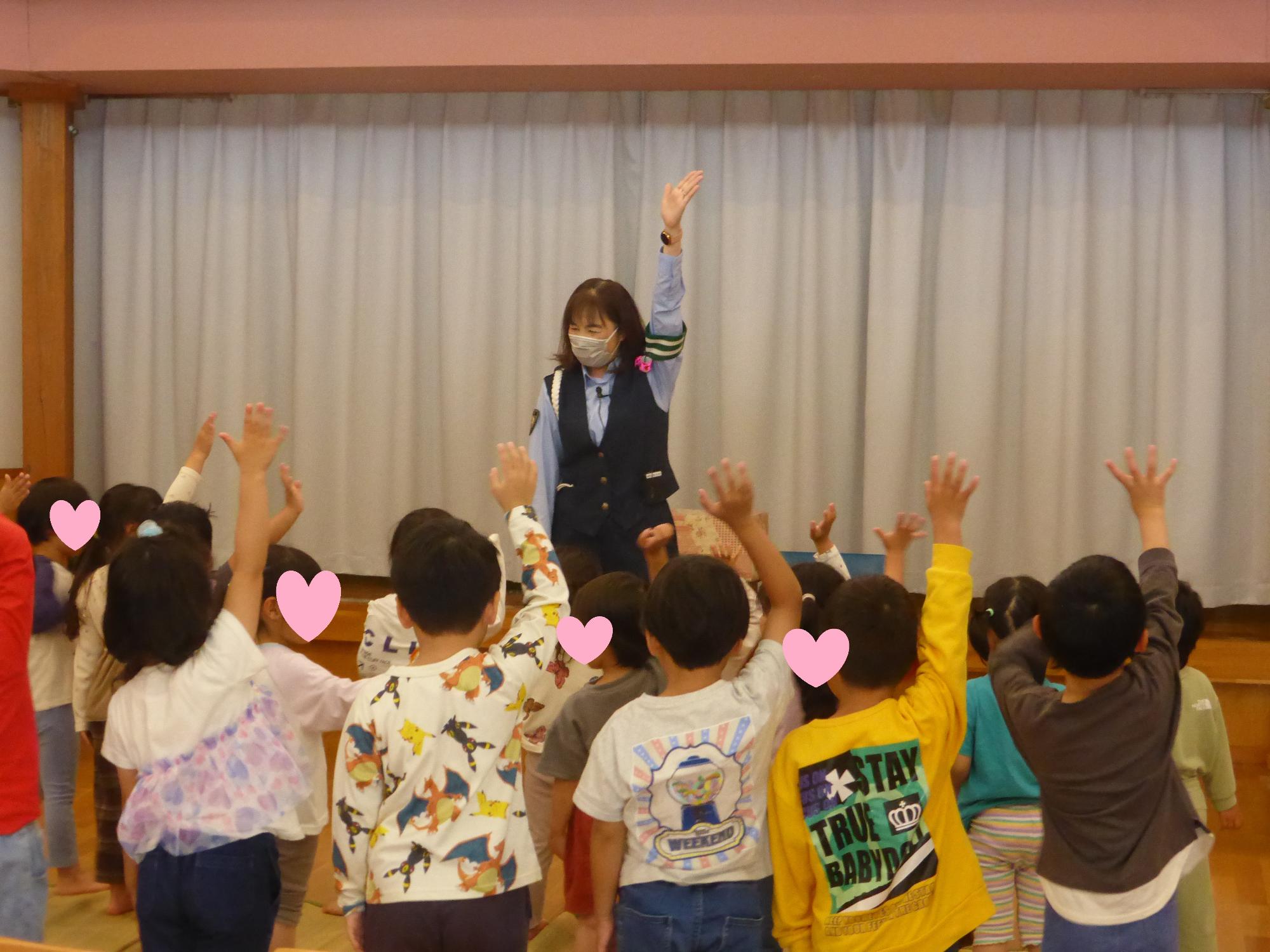 子どもたちが指導員と一緒に手をあげて、横断歩道を渡るときの練習をしています。
