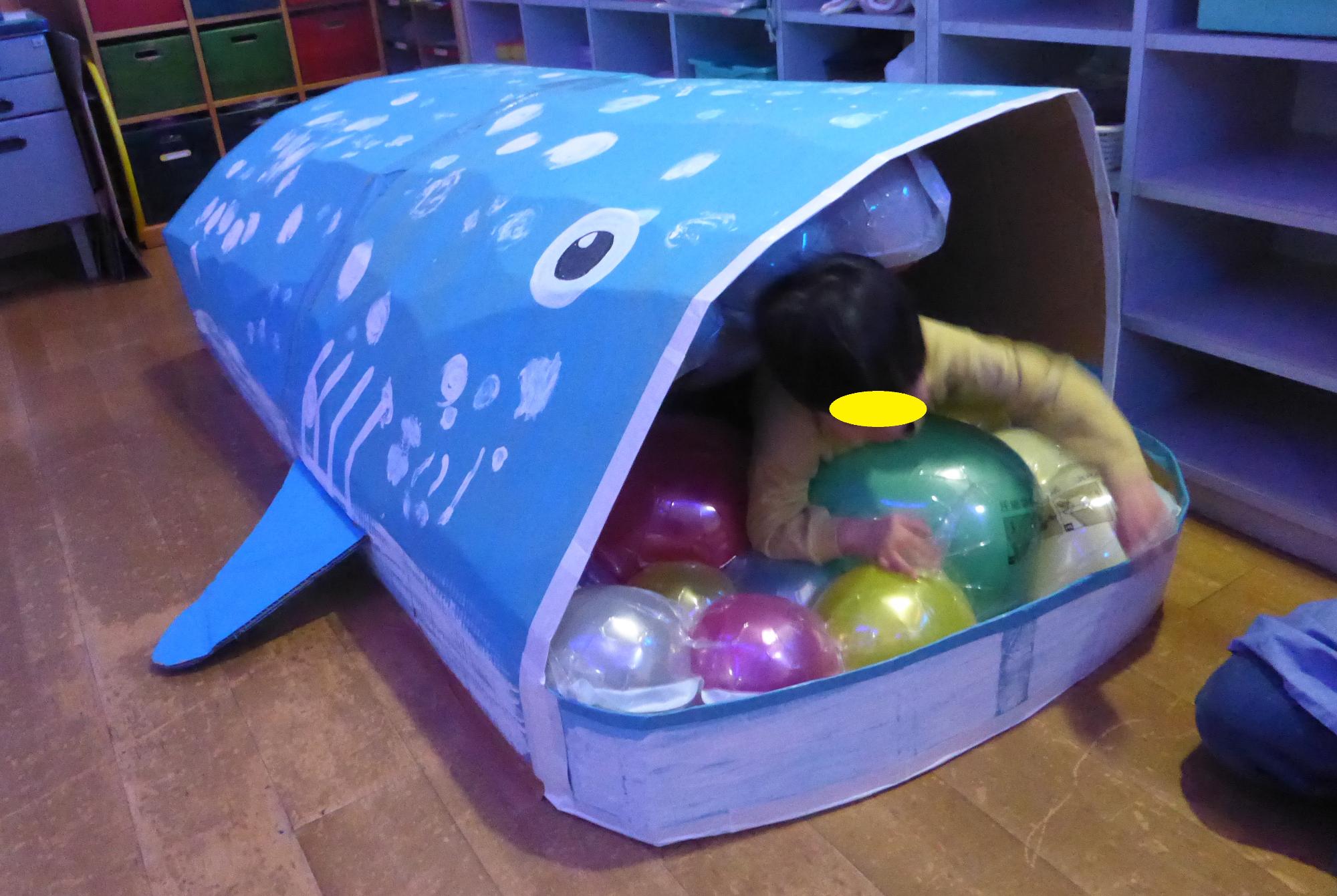 ジンベエザメの口の中のトンネルを通って、子どもたちが遊んでいます。