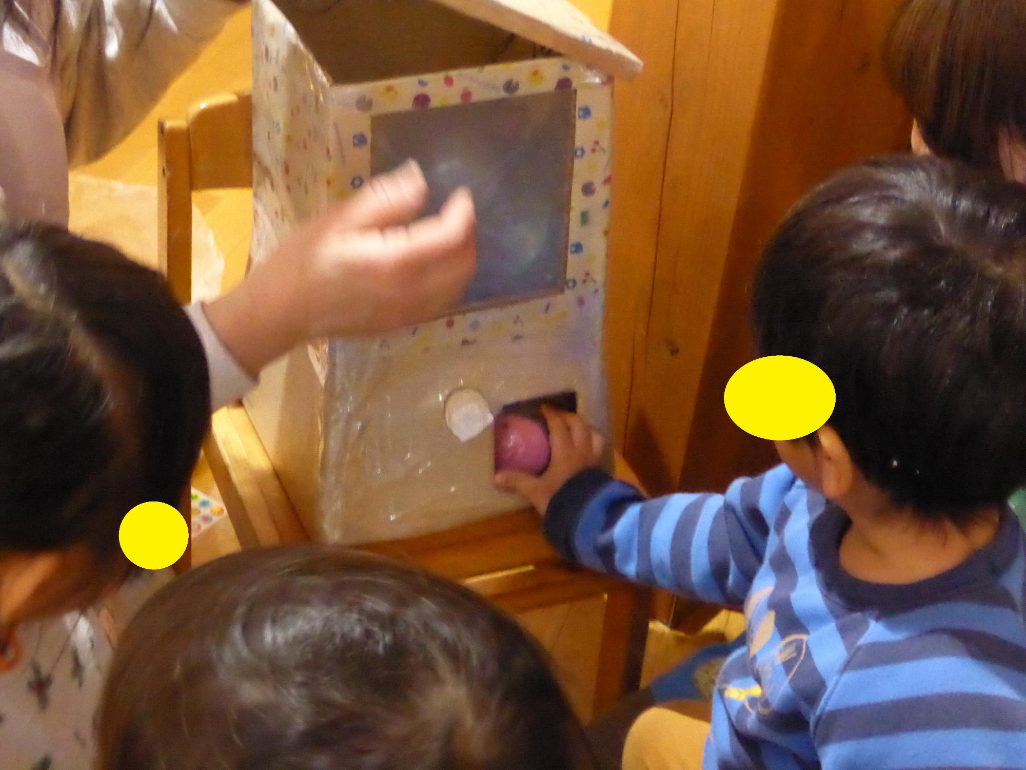 ガチャガチャを回して、出てきたカプセルをとっています。