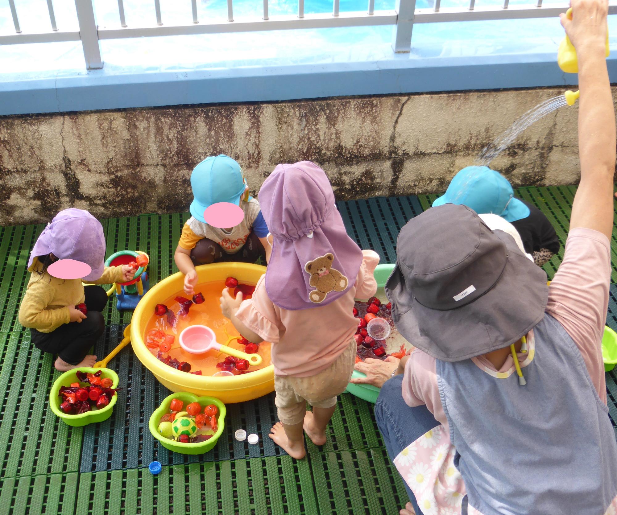 小さいクラスの子どもたちが、おもちゃの金魚すくいをしています。