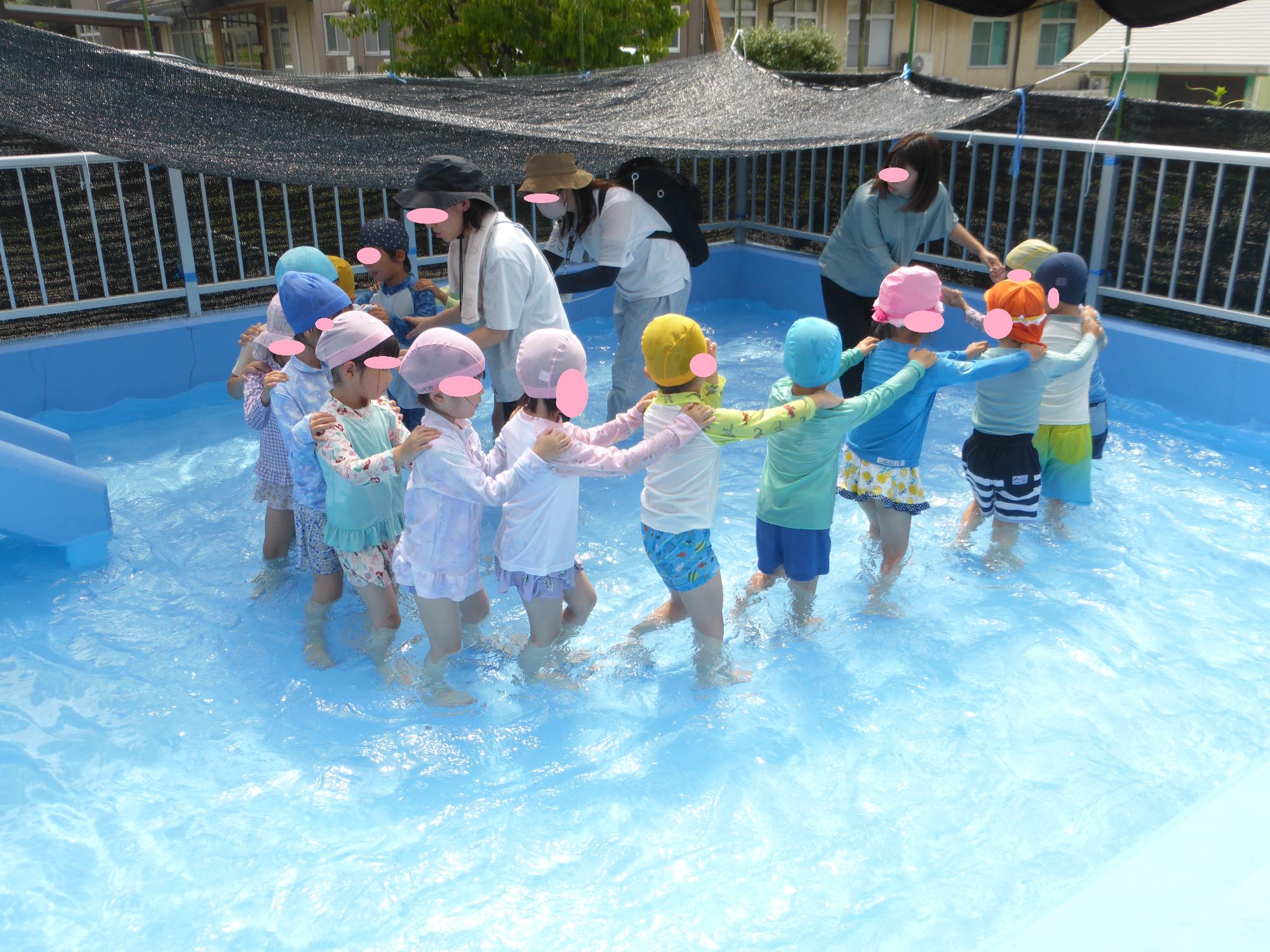 4・5歳児がつながって、プールの中を歩いています。流れるプールをするようです。