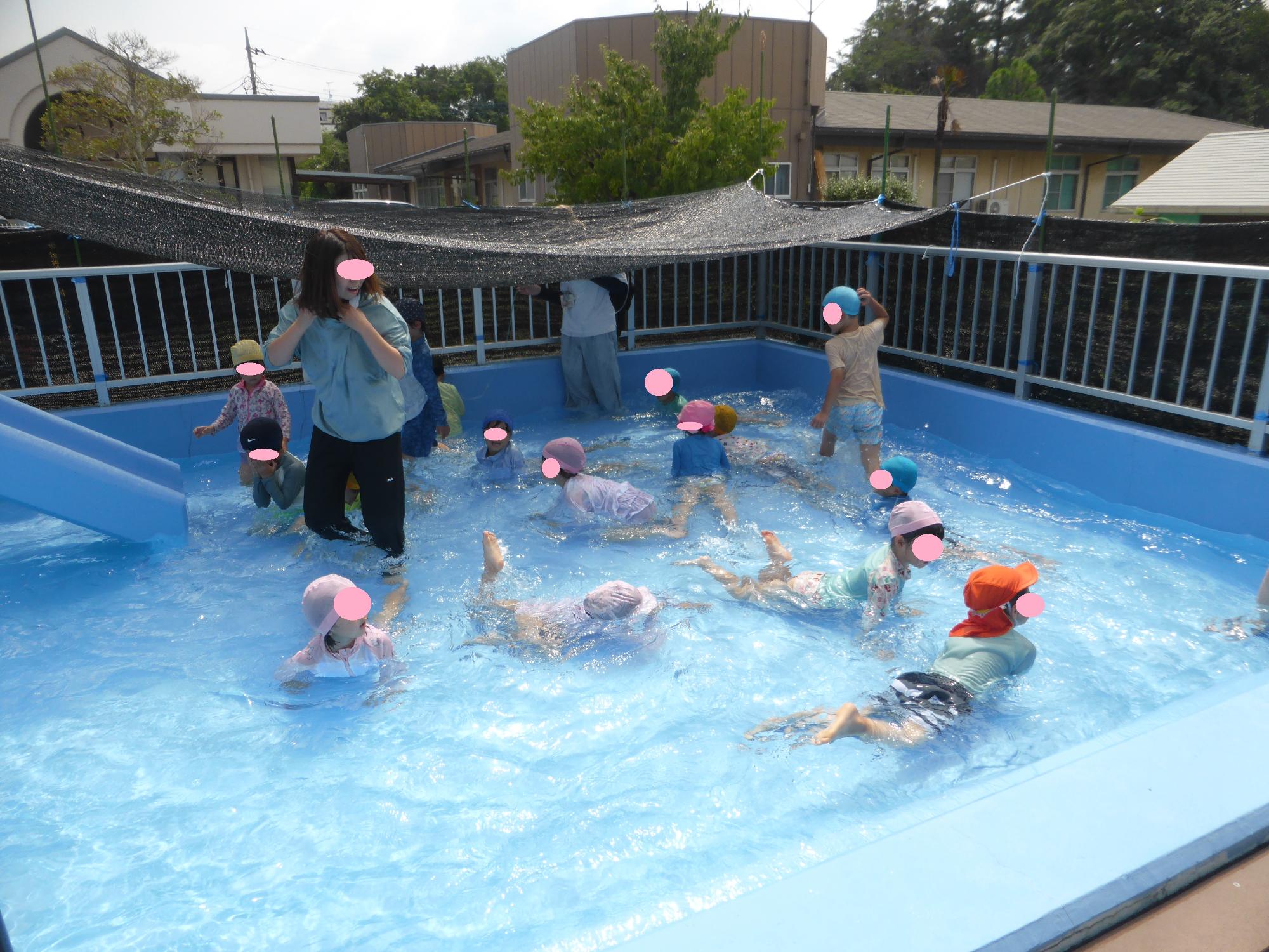 プールの水に流れができたので、子どもたちがワニ歩きをして、泳いでいます。