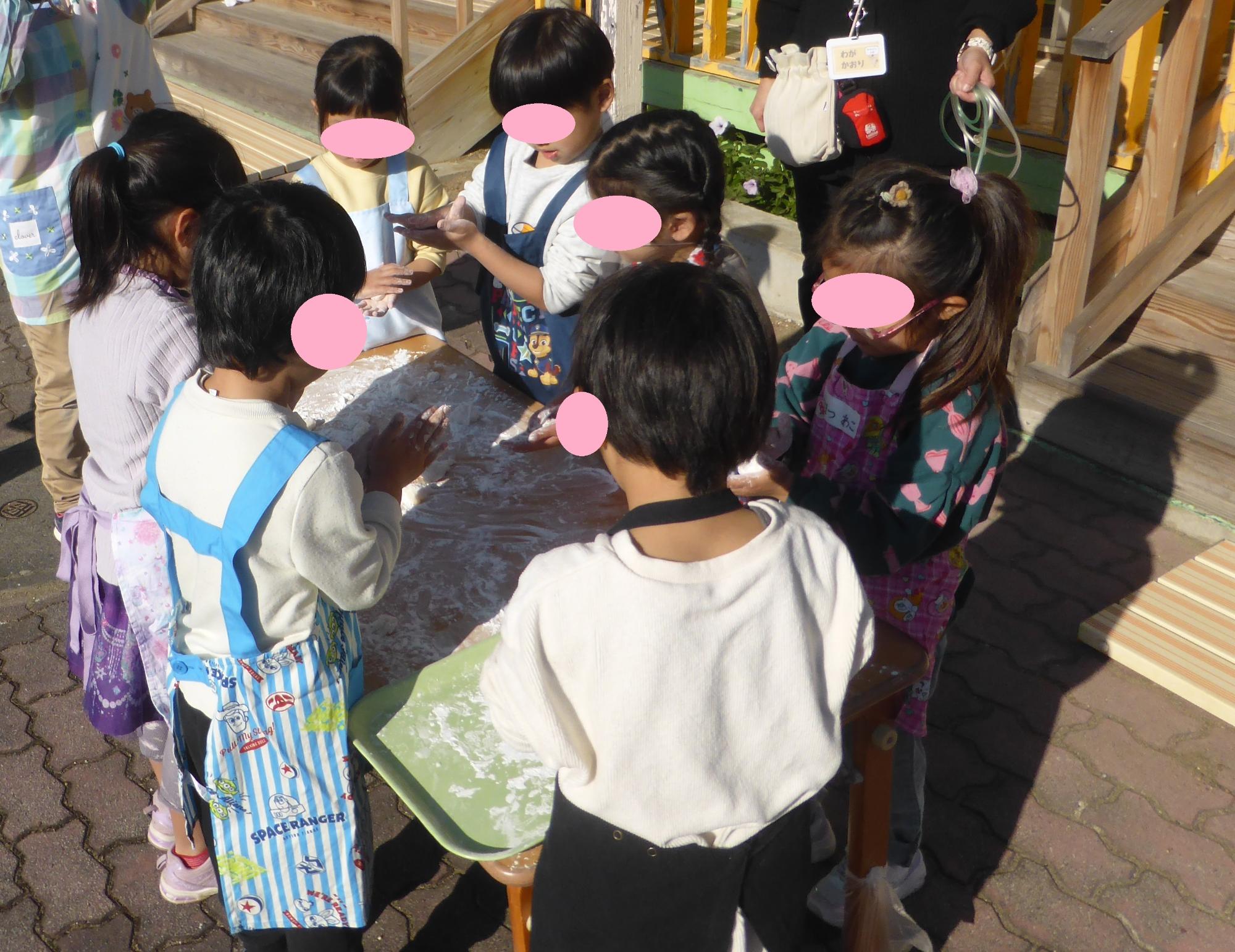 子どもたちが紅白のおもちを丸めています。