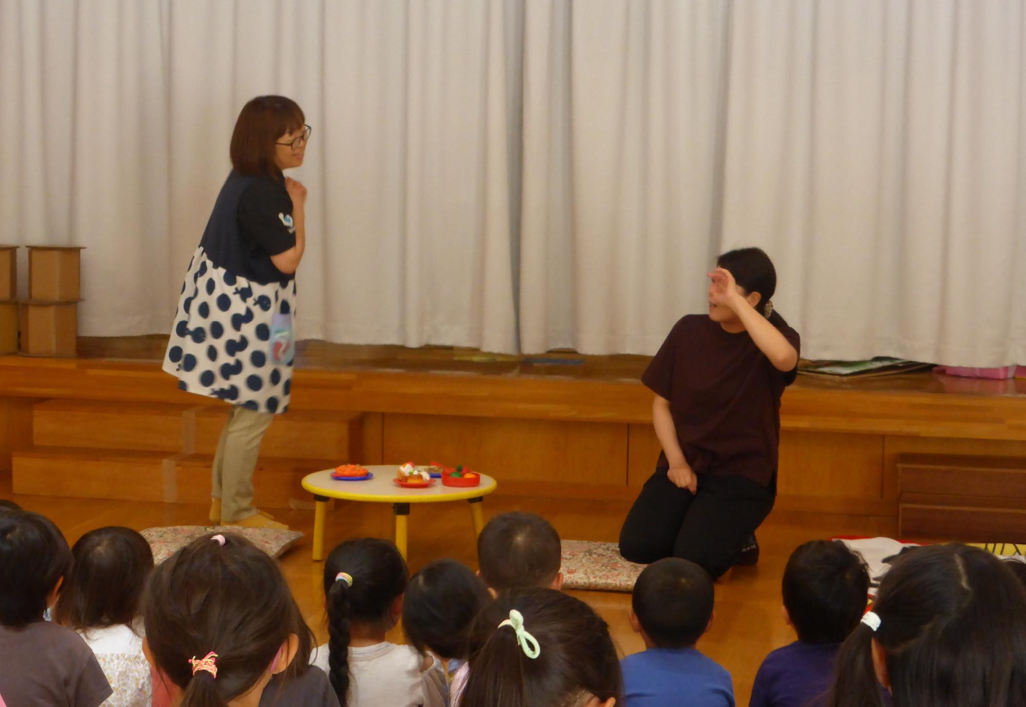 虫歯予防集会で、職員が寸劇をしています。お母さんに歯みがきをするように言われた子は、歯みがきをせずに寝てしまいました。
