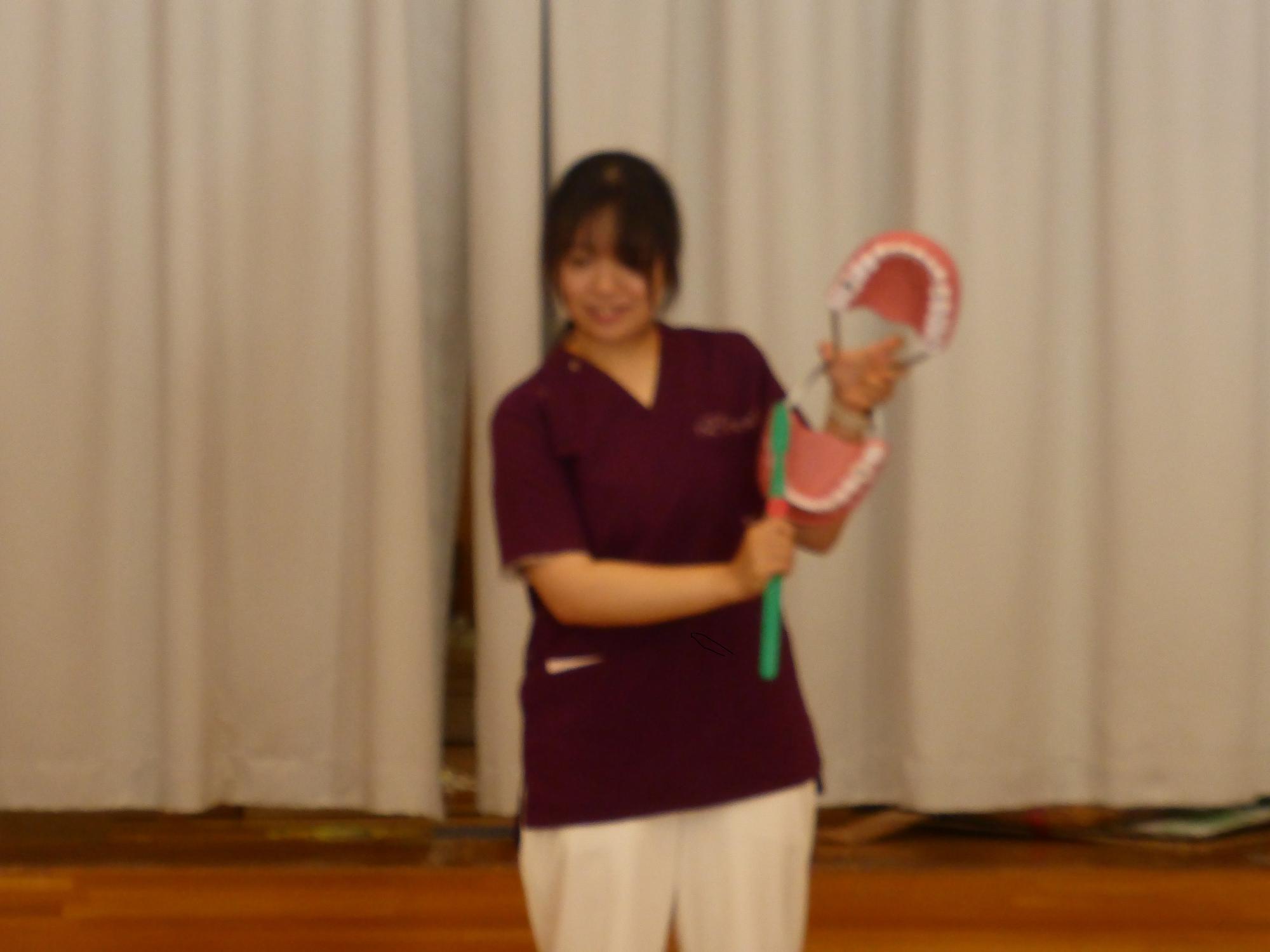 看護師さんから、大型模型を使って、正しい歯の磨き方を教わっています。