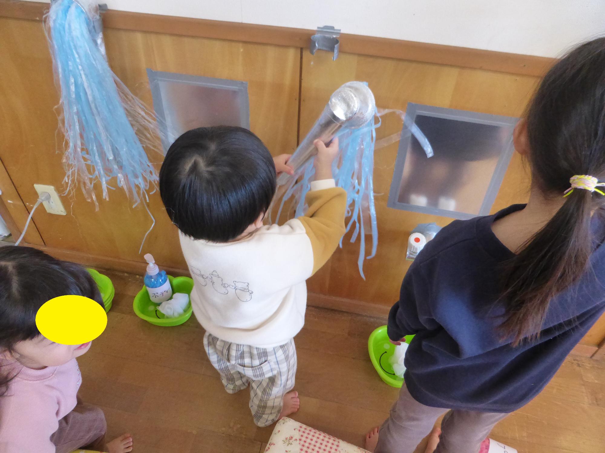 子どもが頭にシャワーをかけています。