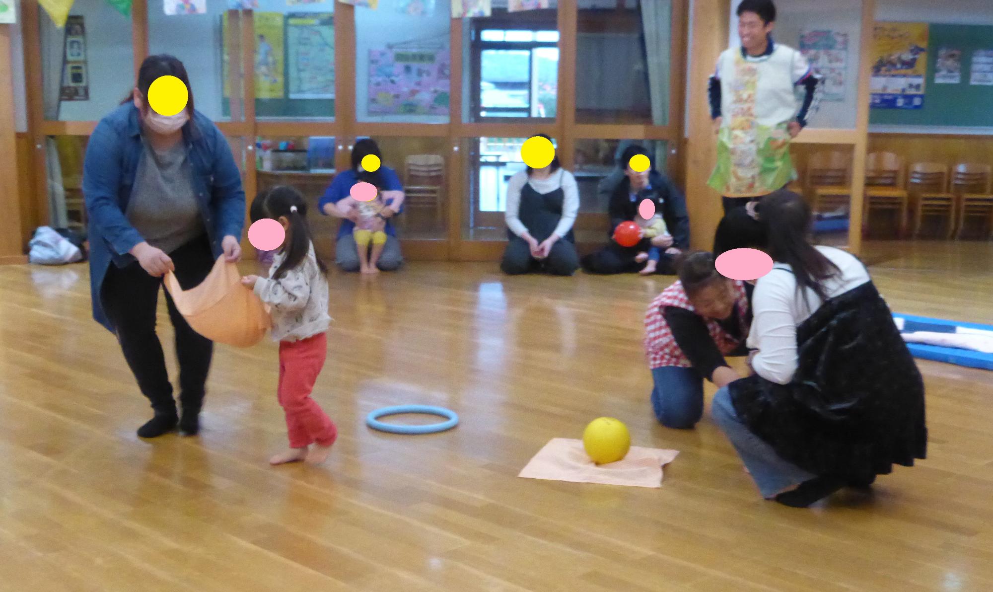 保護者と子どもが布にボールを乗せて、運んでいます。