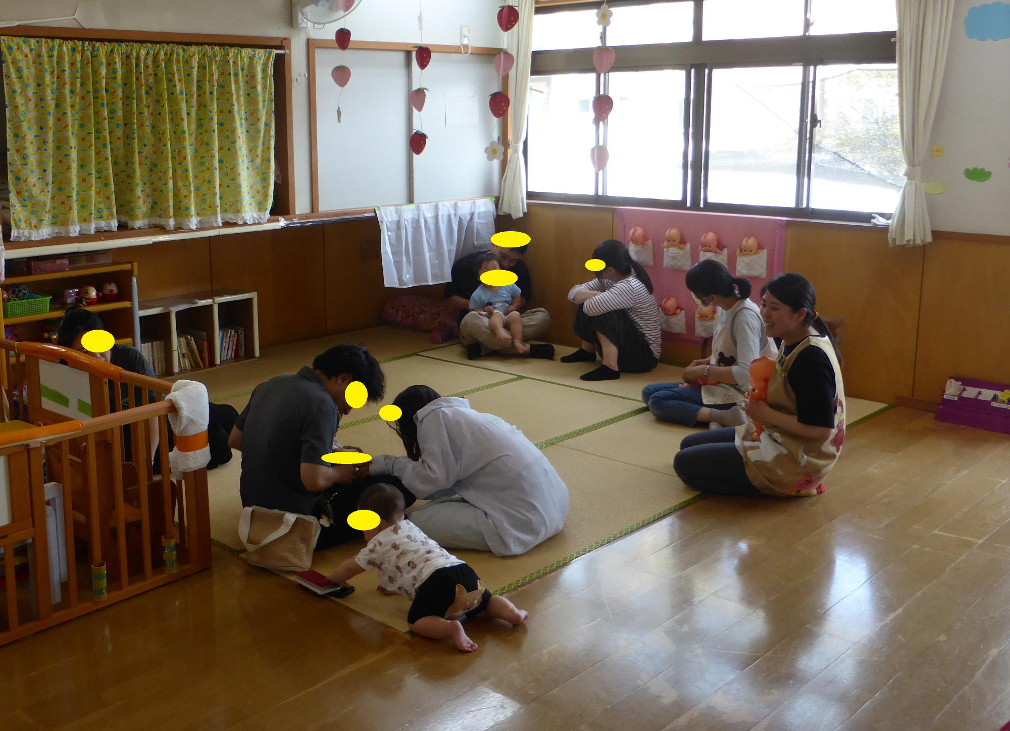 赤ちゃん組の子どもたちが、保護者を触れ合って遊んで笑っています。