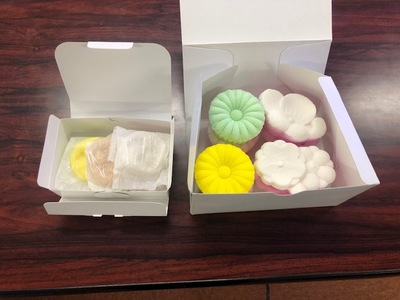 2つの紙製の箱に黄色や緑の砂糖菓子がそれぞれ入っている写真