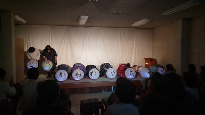 動物のイラストが描かれている2つの和提灯を持った出演者と、一文字ずつ「わわわやたべや」と書かれた7つの和提灯の後ろに座って頭を下げている出演者の公演終了後の写真