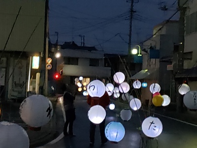 日が暮れた商店街の通りに灯りがついた和提灯が照らされている伊賀七にんげんまつりの様子の写真