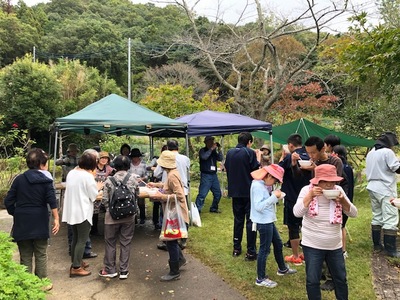 テントの下で振舞われている豚汁を芝桜植栽イベントに参加した方々が集まって食している様子の写真
