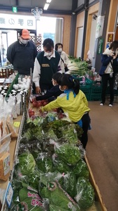 野菜が陳列されている売り場で子供たちがトマトを指さしている職場体験の様子の写真