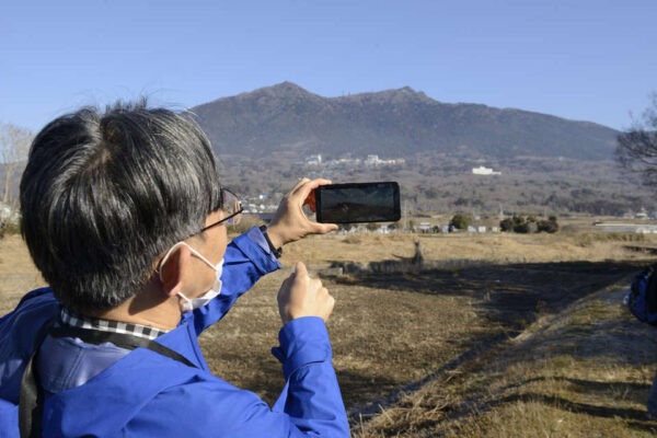 筑波山にスマートフォンを向ける宮地良典さん