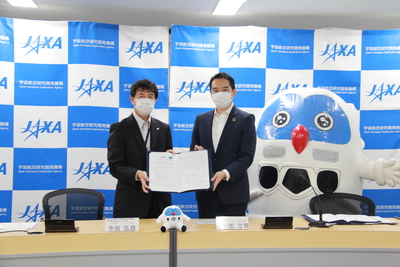 協定書を開いて一緒に持って立っている寺田弘慈氏と市長、その横に立っているフックン船長の写真