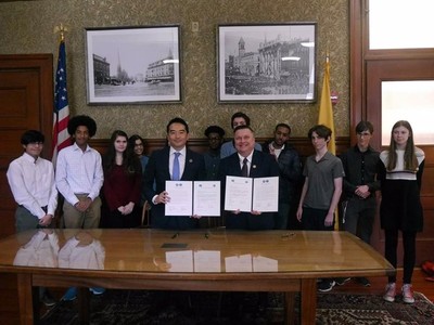 ケンブリッジ市役所にてMarc C.McGovern市長と協定書を更新し関係者と並んでいる五十嵐市長の写真