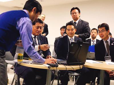 1台のパソコンで会議をしている平井大臣と市長の写真