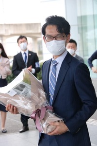 花束を抱えて笑顔を見せる毛塚副市長