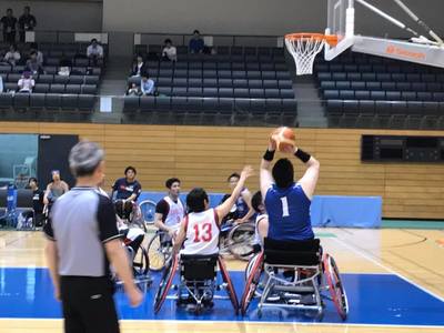車椅子に乗りながらバスケットボールの試合を行っている様子の写真