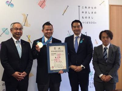 賞状を持っている銀メダルをぶら下げた吉田選手と五十嵐市長の写真