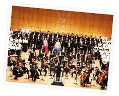 コンサートホールで様々な楽器やコーラス等で演奏を披露している参加者たちの写真