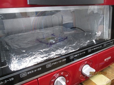 アルミホイルの上にのせたプラバンをオーブントースターで温めている写真
