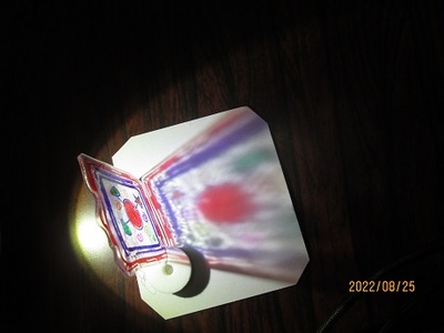 カラフルな絵を描いたプラバン工作の作品の後ろから光を当てている写真