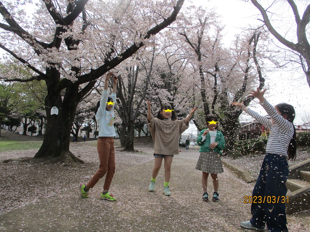 桜のはなびらを集めて、花吹雪を自分たちで作って遊ぶ子供たち