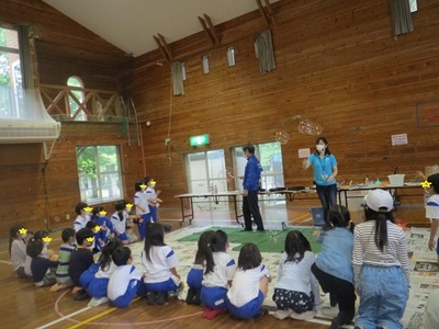 シャボン玉ショーに子ども達は興味津々の様子の写真