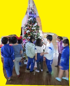 大きなクリスマスツリーの周りに集まる子どもたちの写真