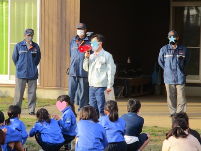 避難訓練で話を聞いている子供たちの写真