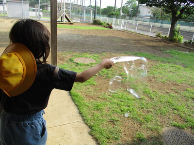 大きなしゃぼん玉を作ろうとしている様子の写真