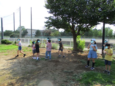 木陰でかき氷を食べている子どもたち写真