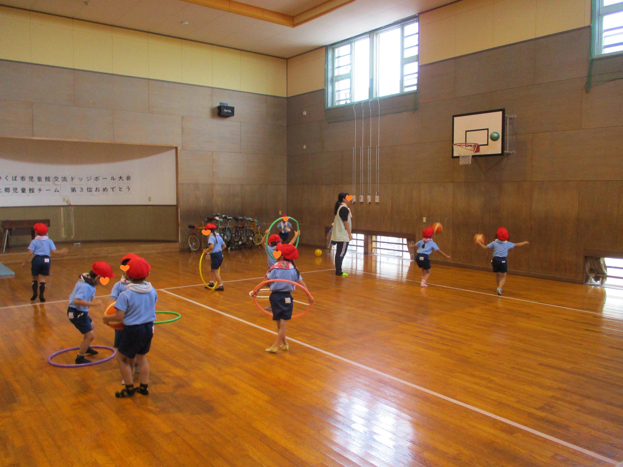 フラフープやボールで遊ぶ園児