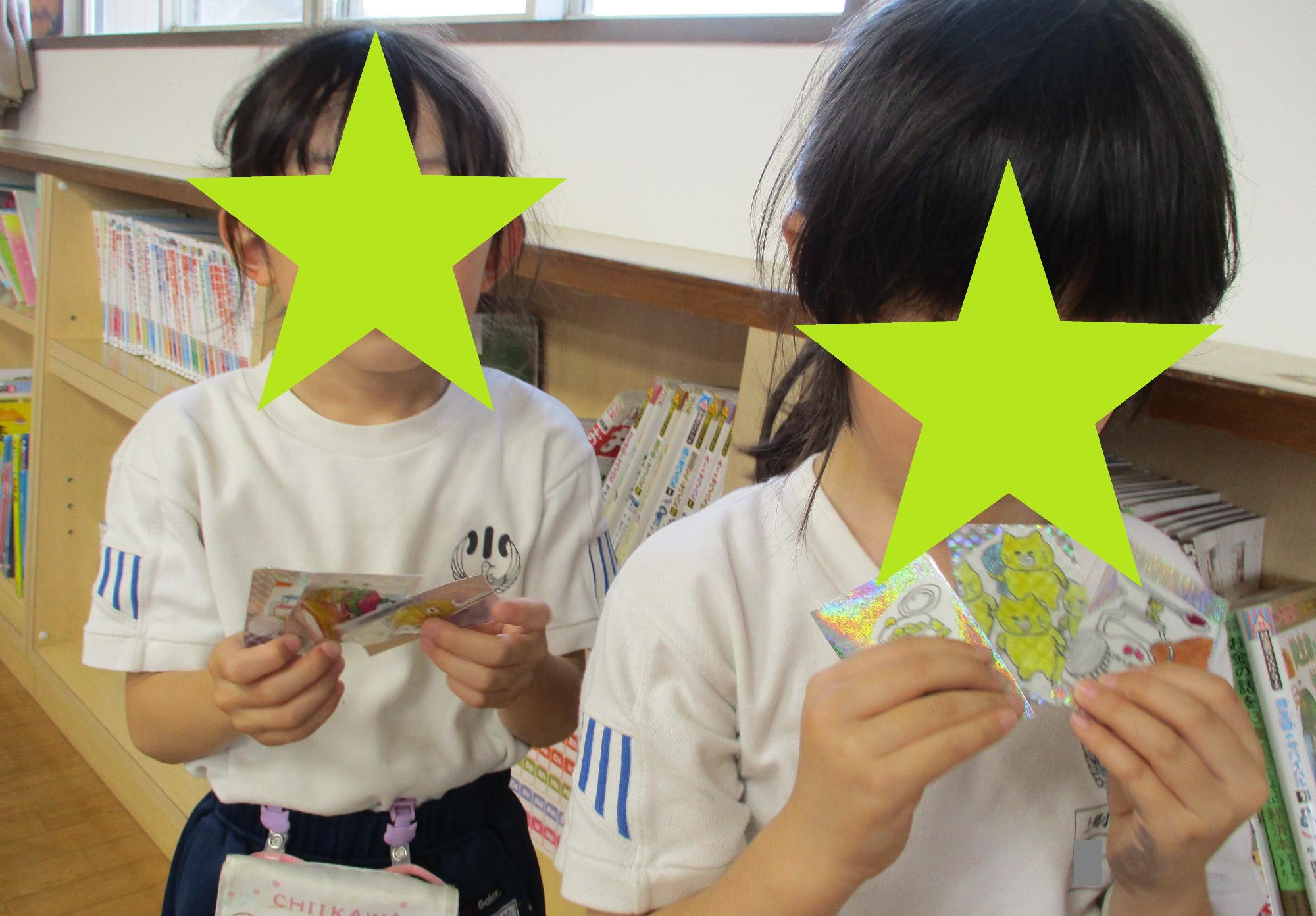 完成したキラキラカードを持つ2人の子ども