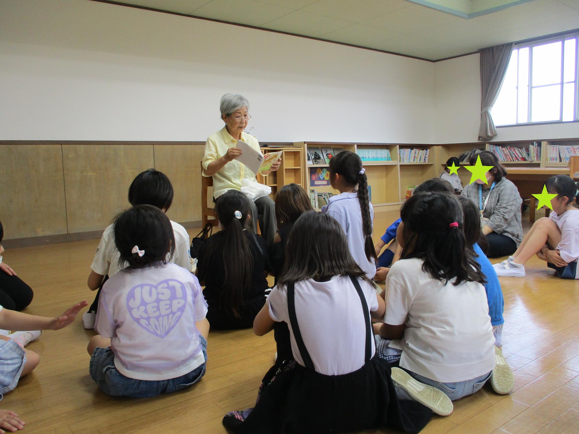子どもたちに読み聞かせをする先生
