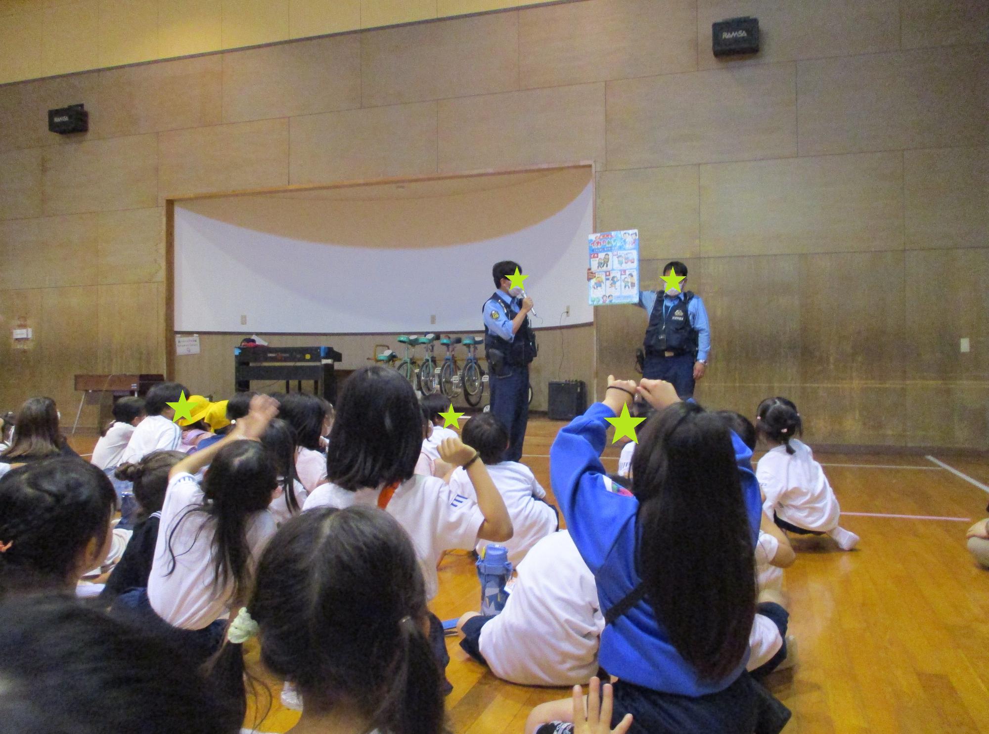 2人のお巡りさんのお話しを聞く子どもたち