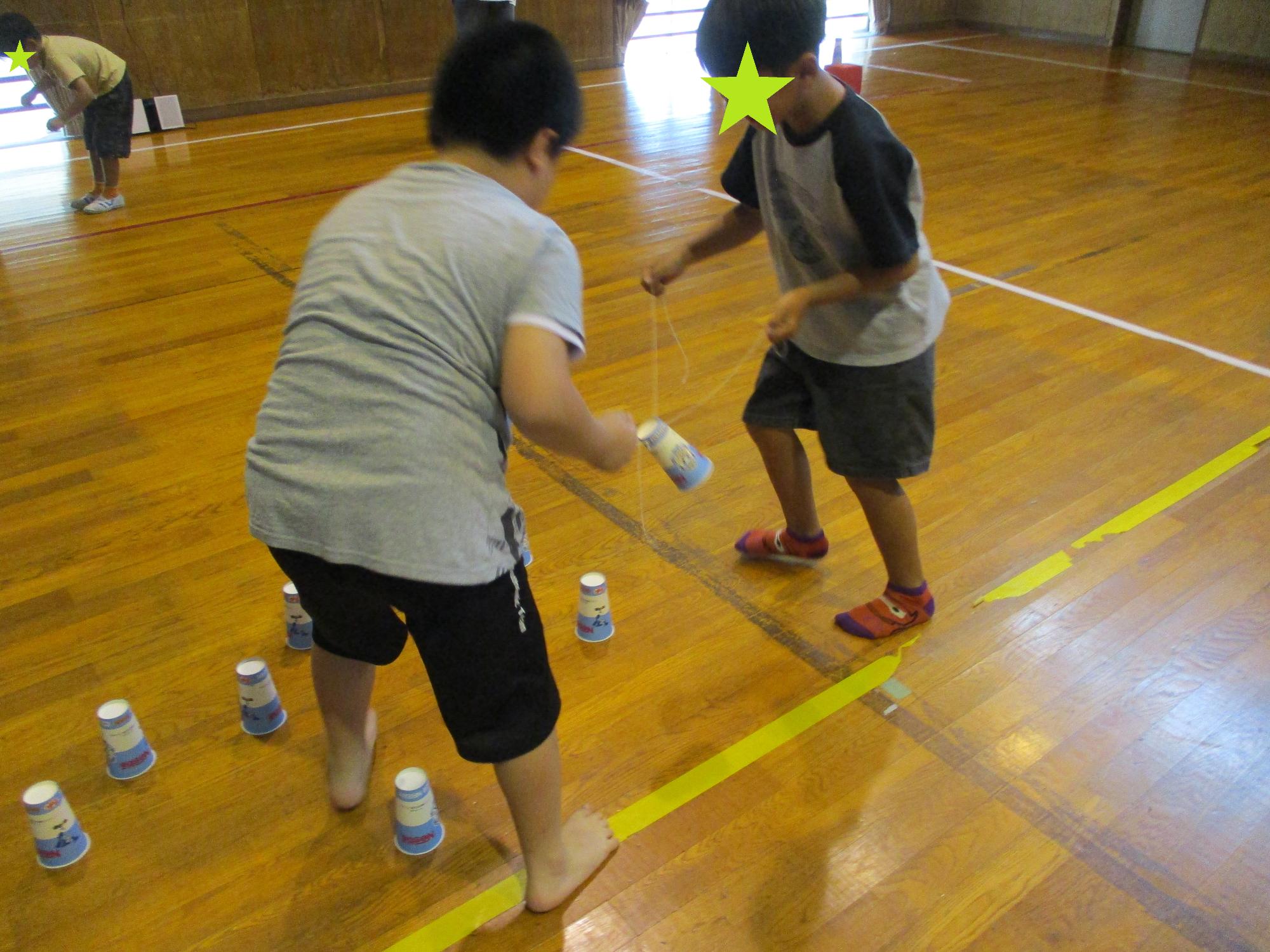 コップ運びリレーをする子どもたち