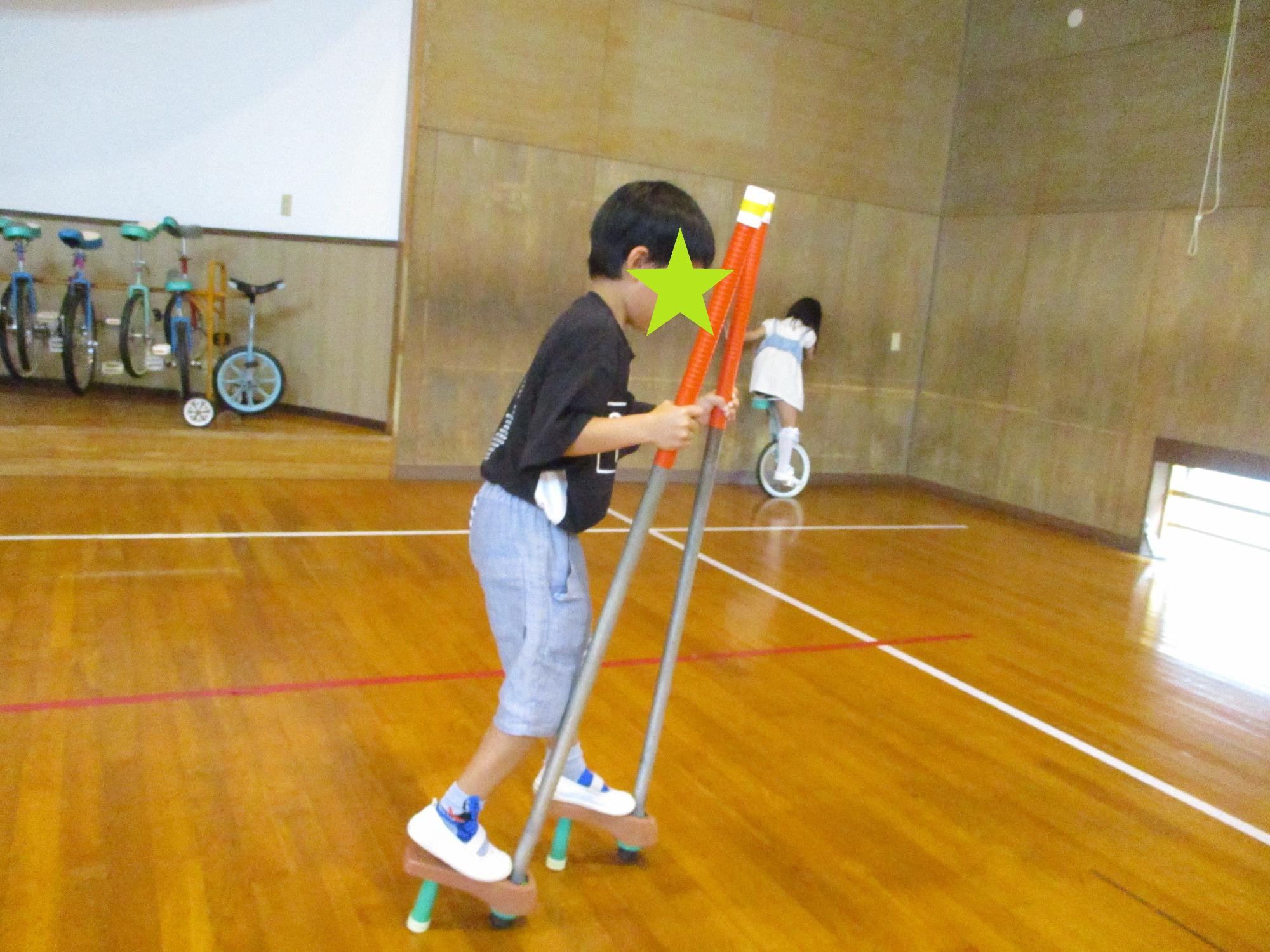 竹馬の練習をする子