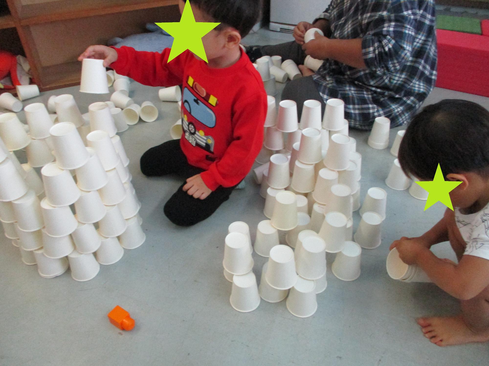 紙コップでタワーを作る2人