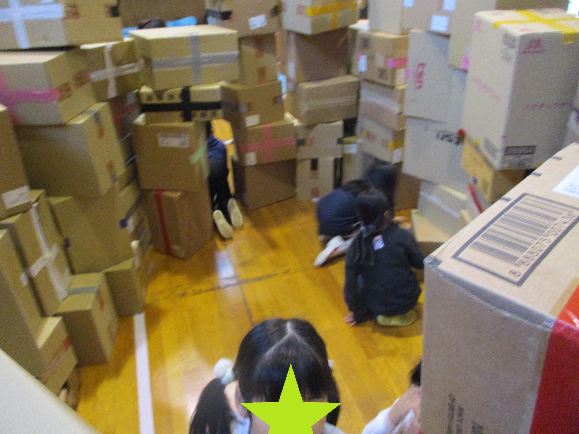 ダンボールつみきで作った囲いに入って遊ぶ子どもたち