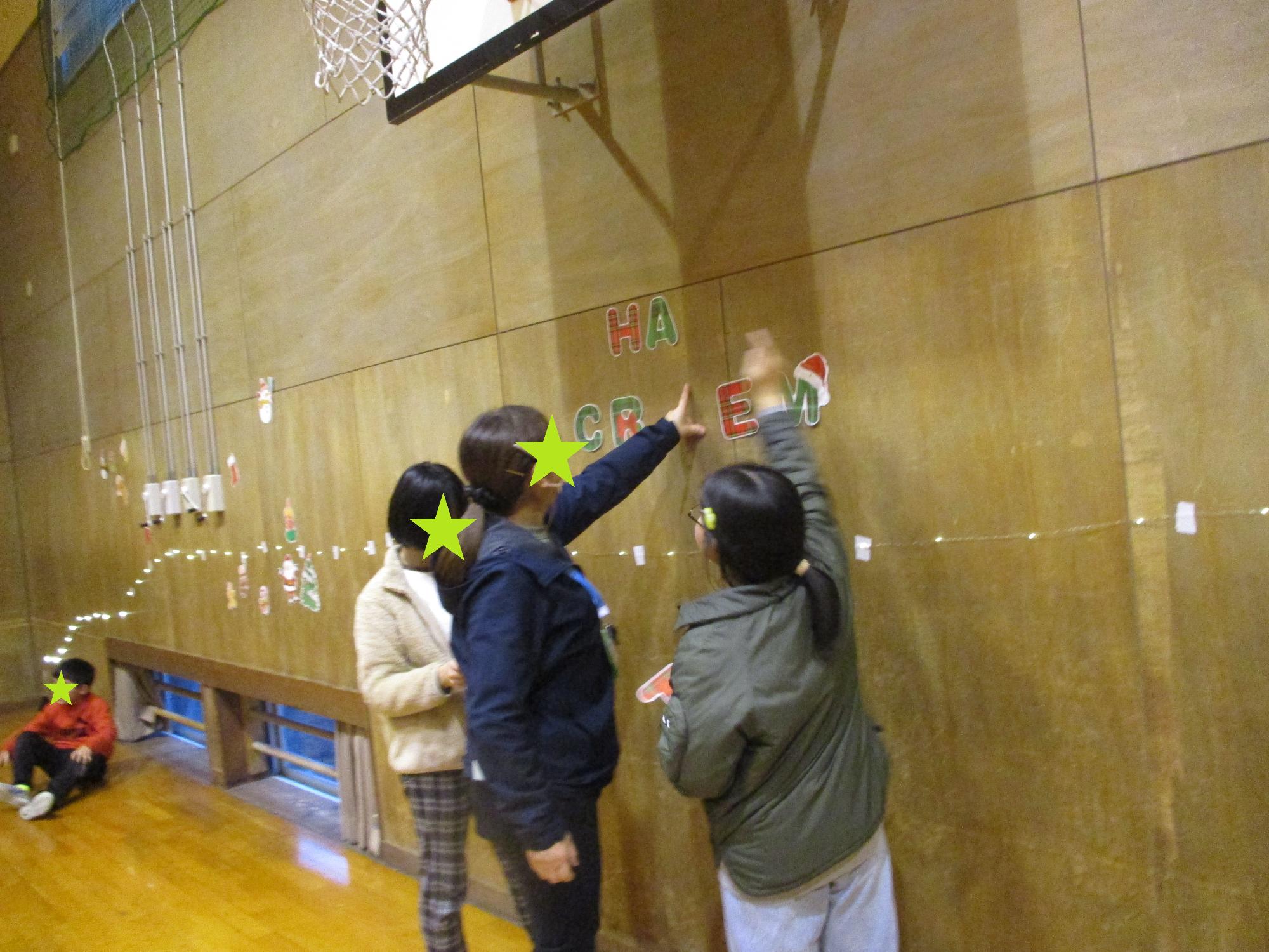 クリスマスの飾りつけをする子どもたちと先生