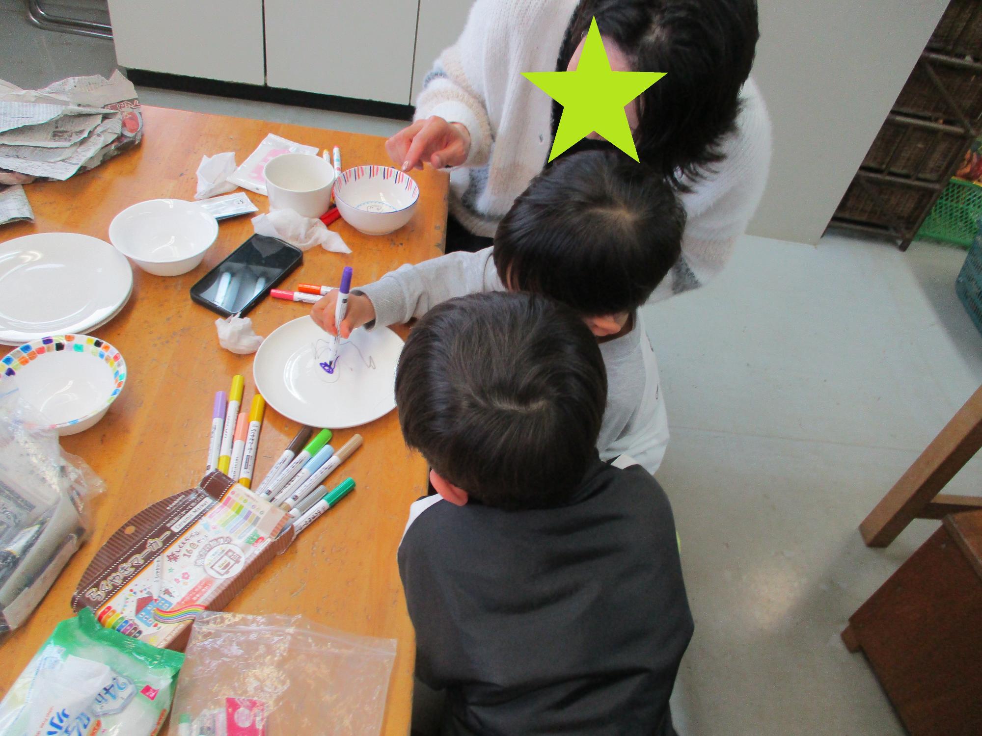 お皿に絵を描く親子