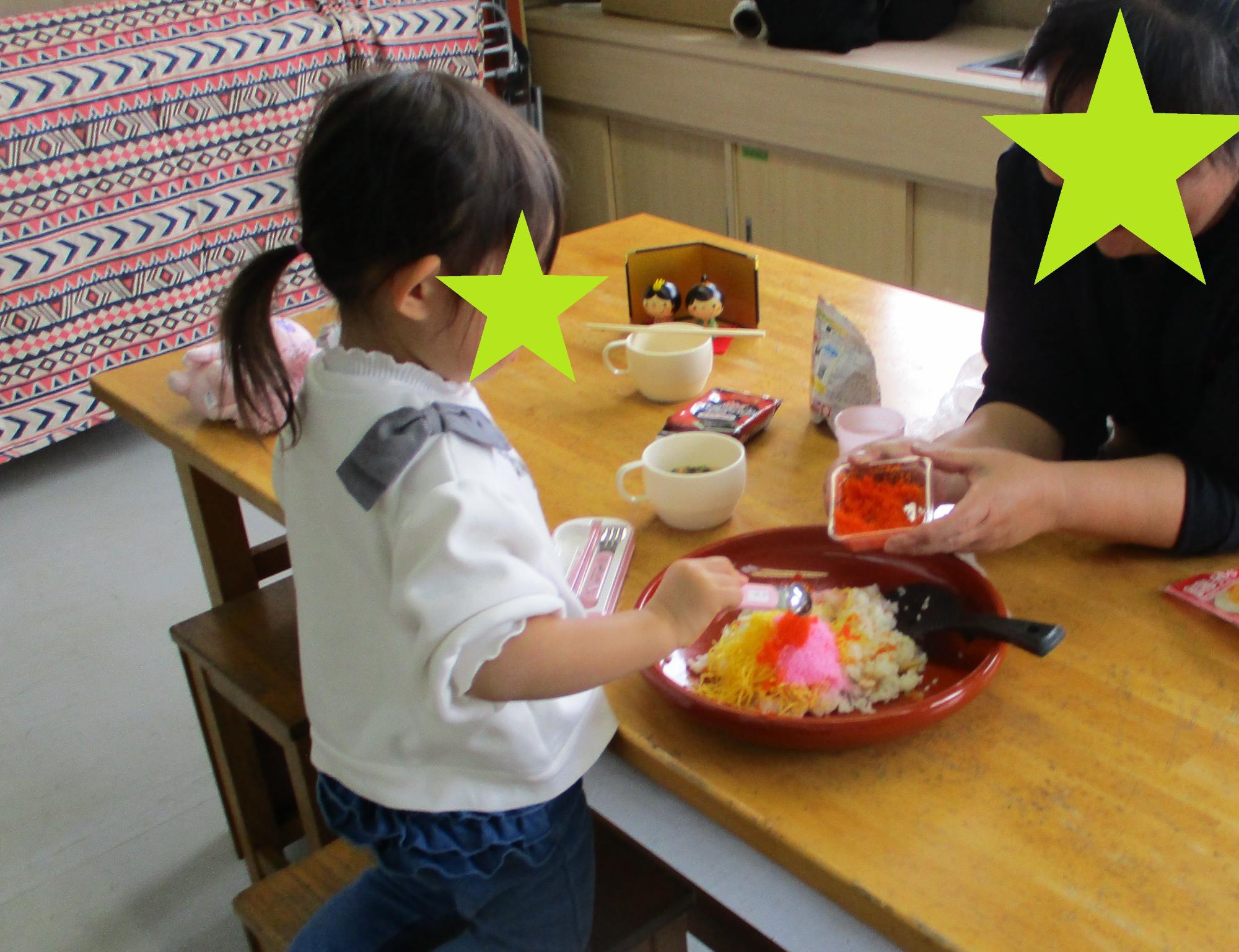 ちらし寿司にとびっこを乗せる女の子