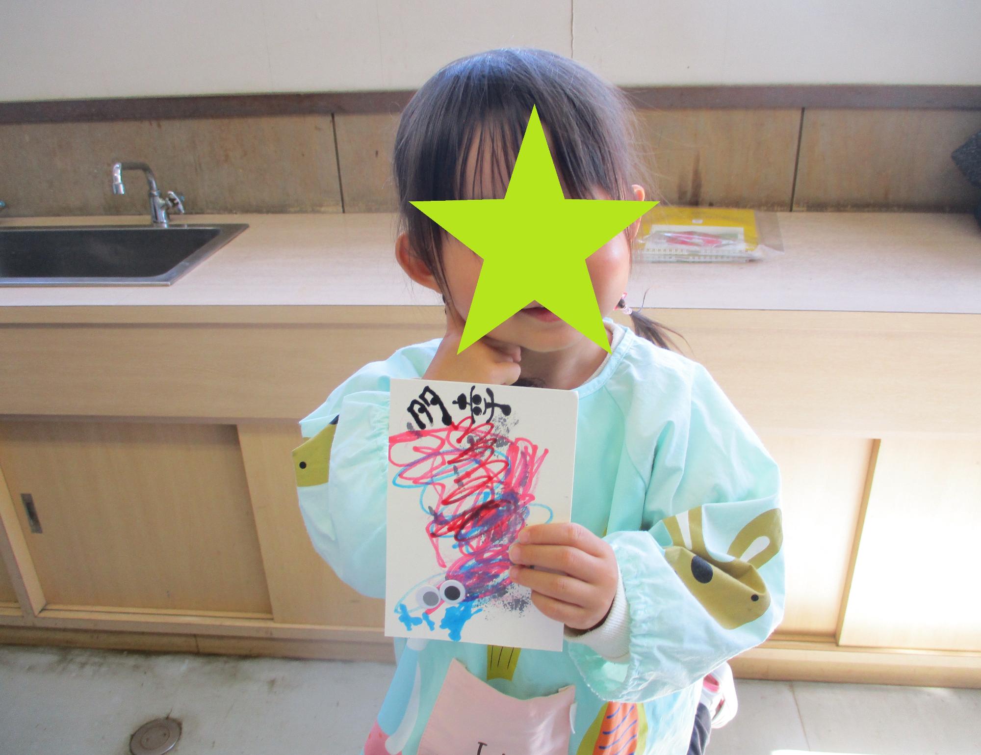 完成した己書を持って決めポーズをする女の子